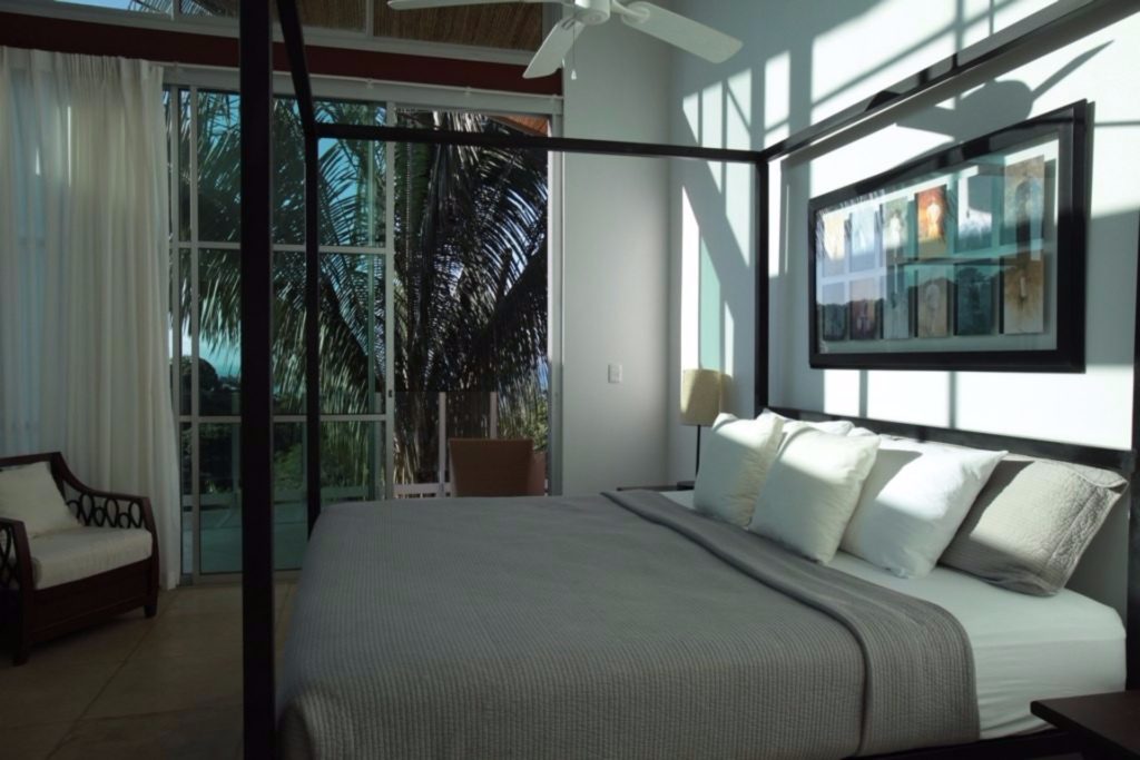 The open feel of this bedroom is accentuated by the glass balcony doors and the king poster bed. 