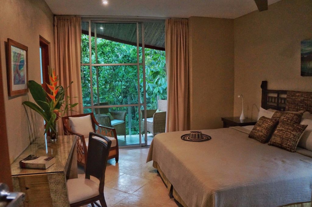 This lower-level bedroom features a king bed, exquisite furnishings, and a private jungle-view balcony.