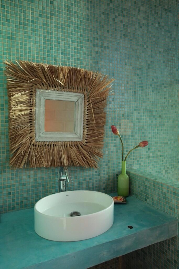 This handcrafted straw and distressed wood mirror is a unique feature in one of the ten bathrooms.