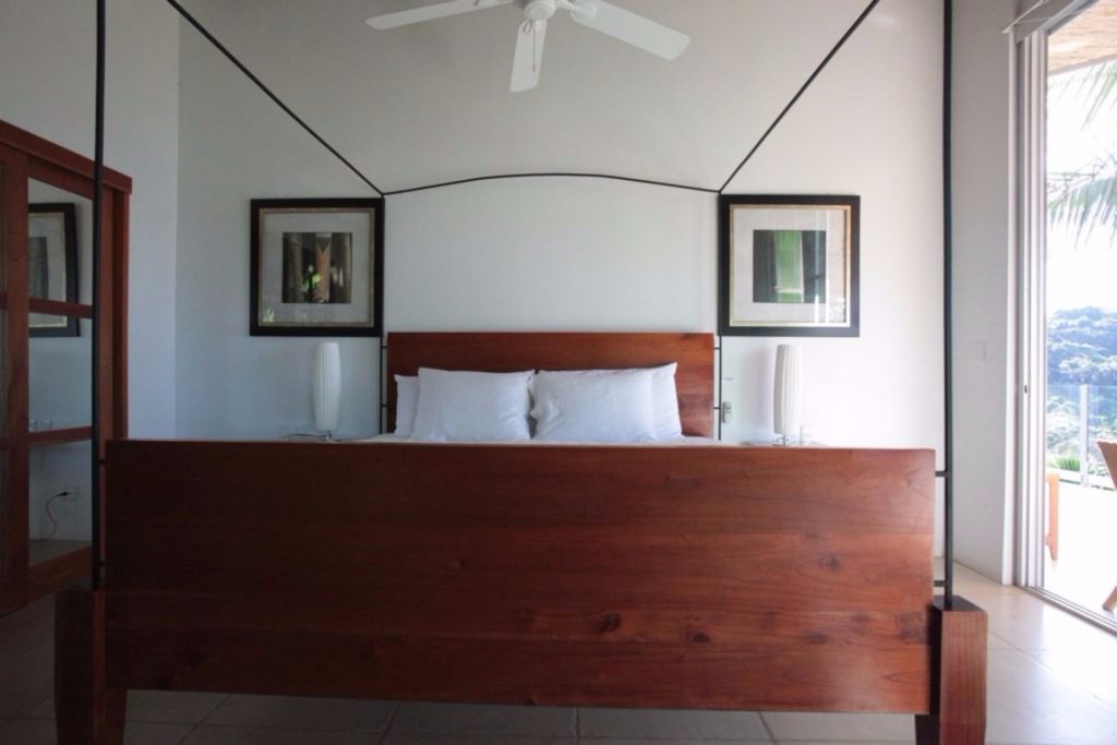This luxury bedroom features a beautifully-designed hardwood king poster bed.