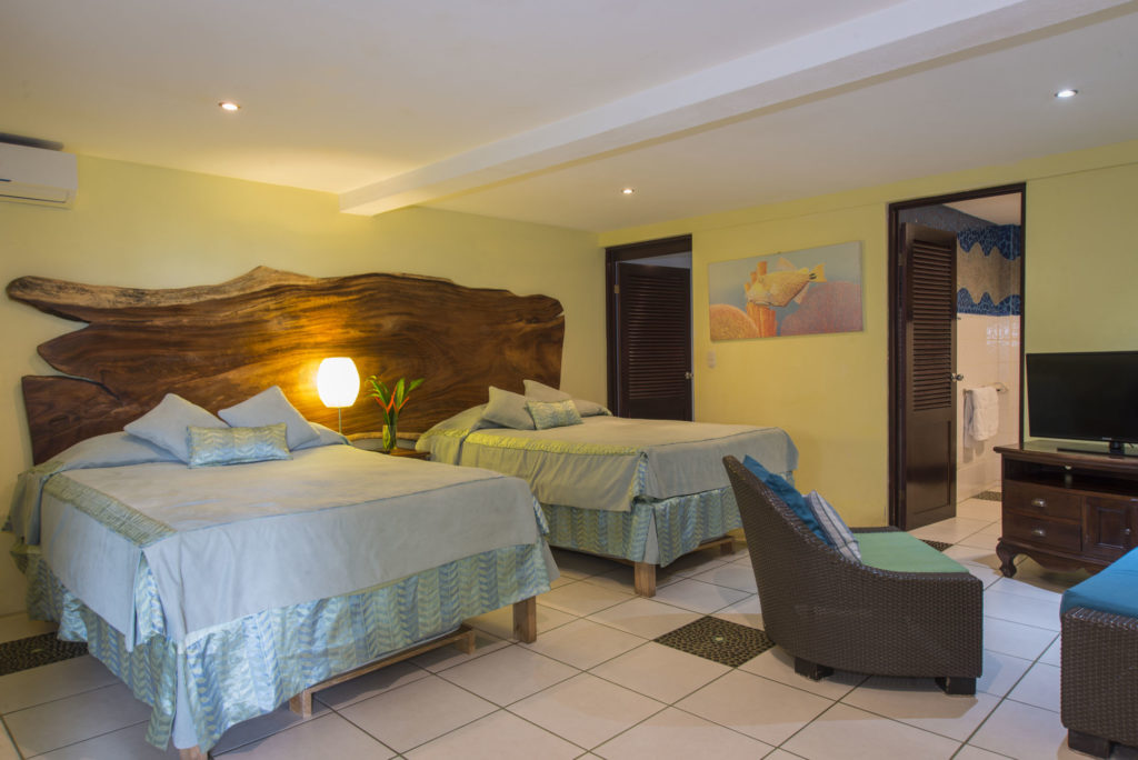The villa can sleep up to fourteen. This bedroom has two queen beds, two pull-out beds, and a sitting area.