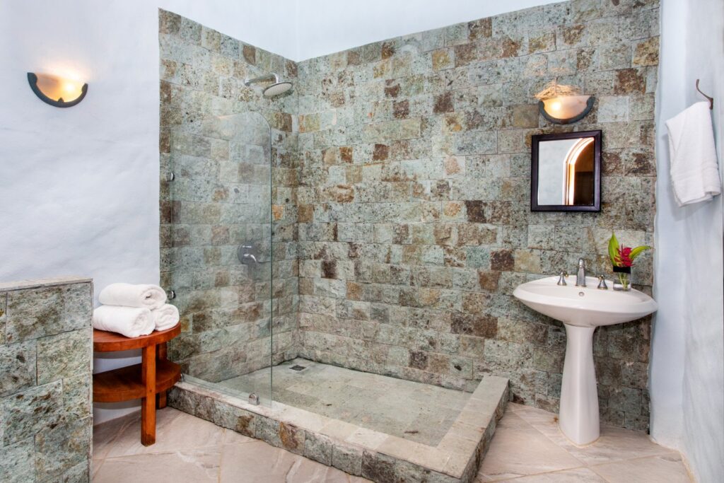 This beautiful custom-designed bathroom features a natural stone wall and is located just off the games room.