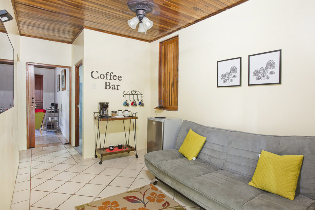 The entryway in the smaller house has a coffee bar, small refrigerator, and a comfy sofa.