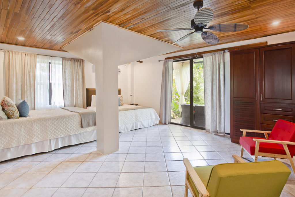 The lower-level bedroom in the smaller house has two queen beds with beautiful tile floors and wood ceilings.