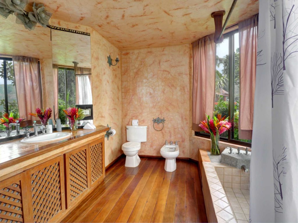 The master ensuite features natural wooden floors and a large tiled bathtub.