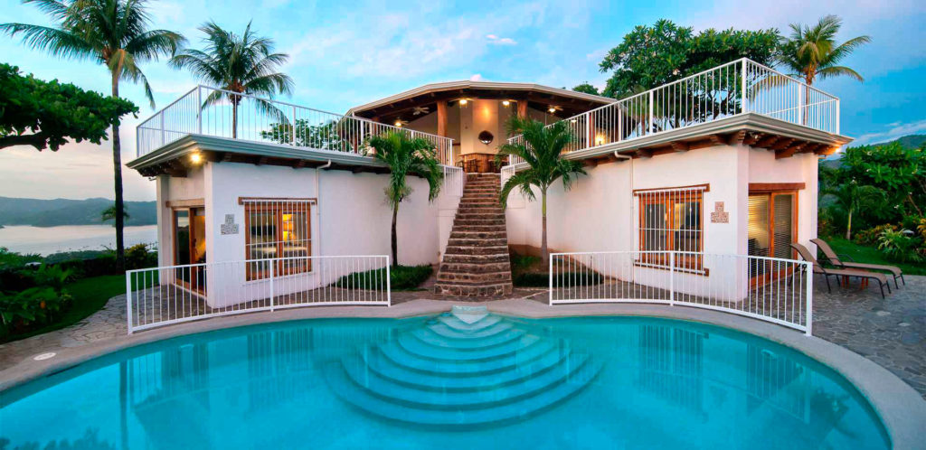 The large private pool has a unique design with steps leading to the upper-level patio.