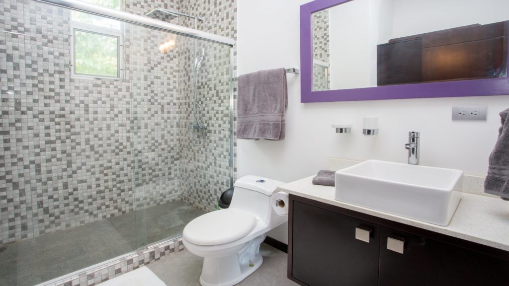 The contemporary design of this bathroom includes a large tiled luxury rain shower.