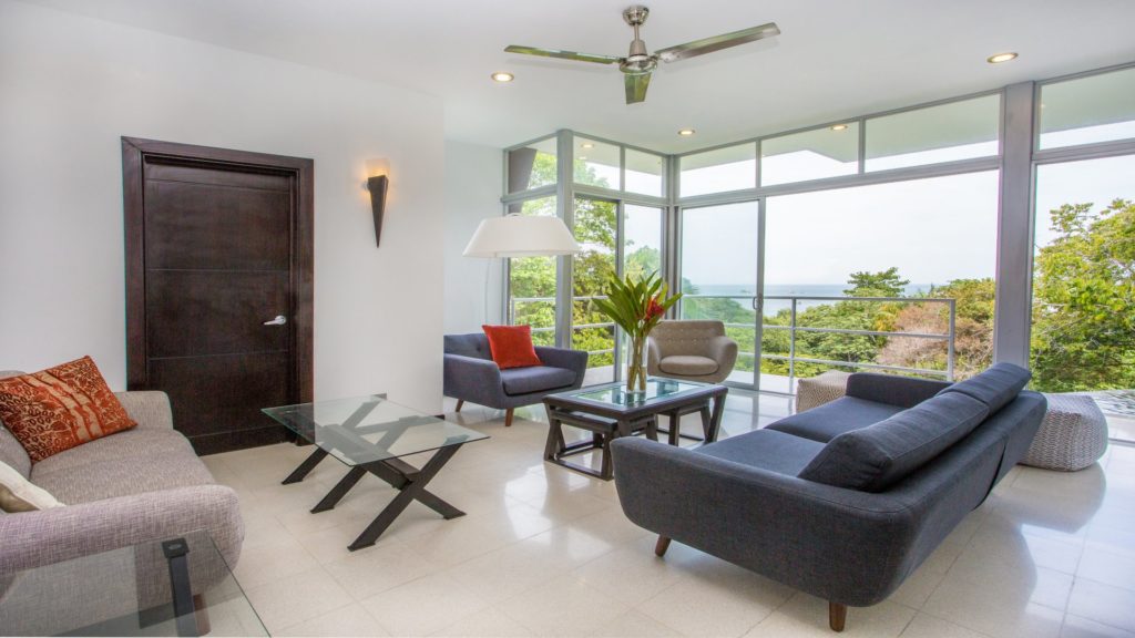 Floor-to-ceiling glass opens the living room up and brings the tropical outdoors into the villa.