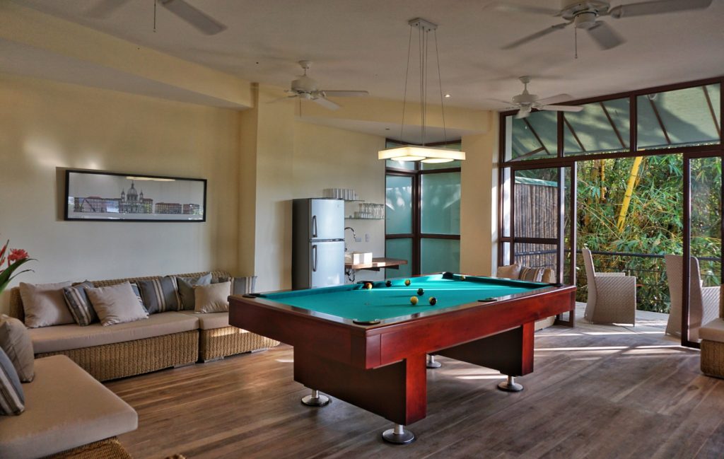 The games room features a regulation pool table, comfortable seating areas, and a bar.