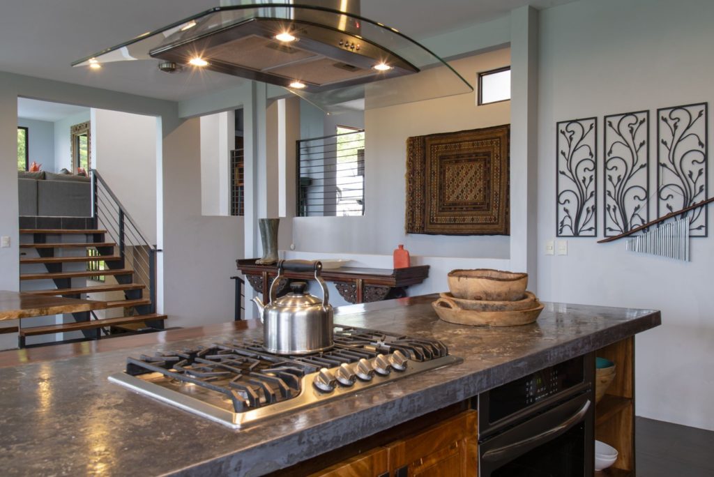 The kitchen features a superb island with a modern overhead stove hood.