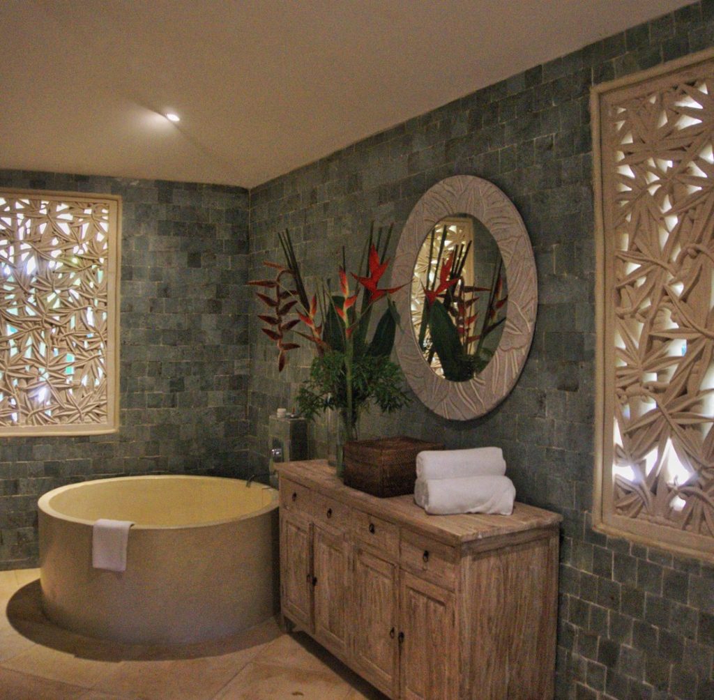 High end design in the master bathroom with natural stone tub, shower, and sinks. 