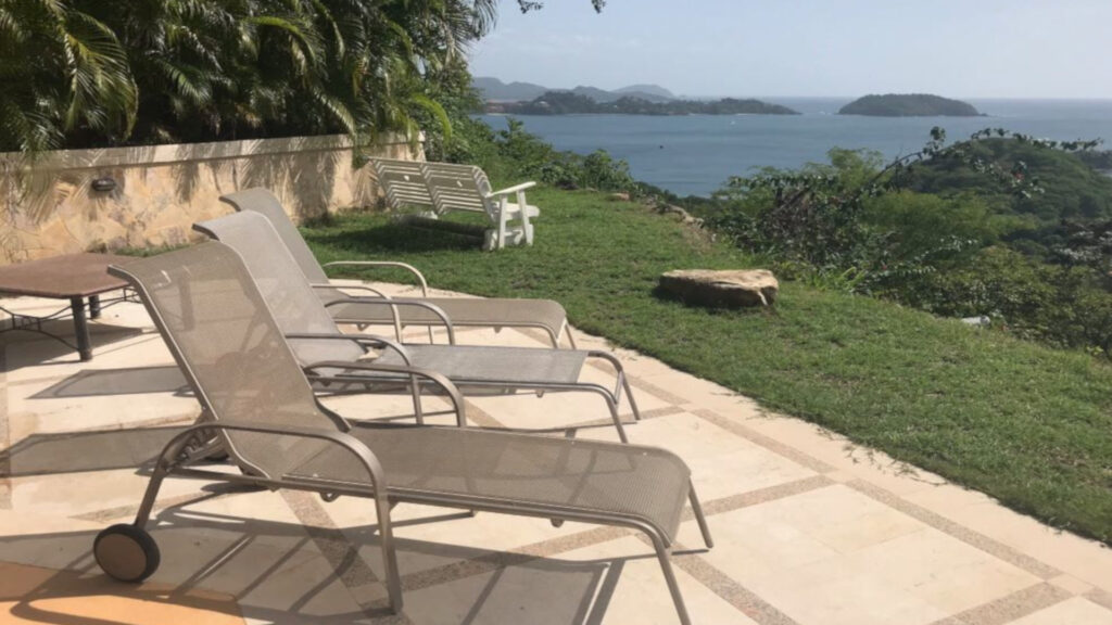 Lounge chairs by pool, along with rocking love seat.