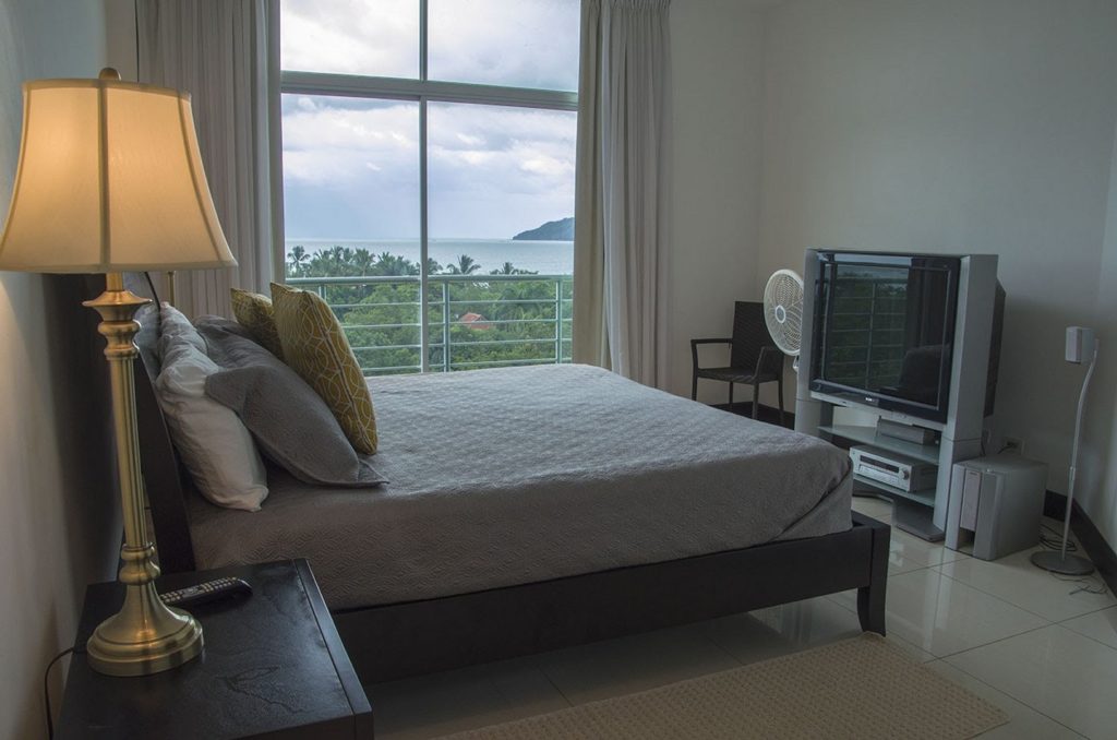 Large bedroom and television with ocean views.