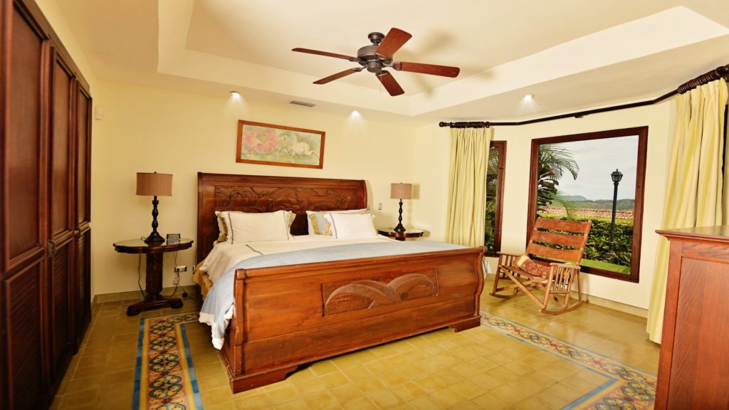 Recline upon this sumptuously appointed bed, with a view to lush gardens, enhancing your vacation retreat.