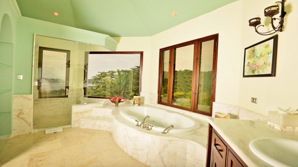 Indulge in opulence within this exquisite bathroom marvel, featuring a sumptuous bathtub, a polished shower, and an awe-inspiring ocean view.