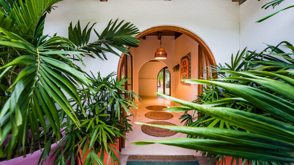 The home has many curved archways and lots of greenery.