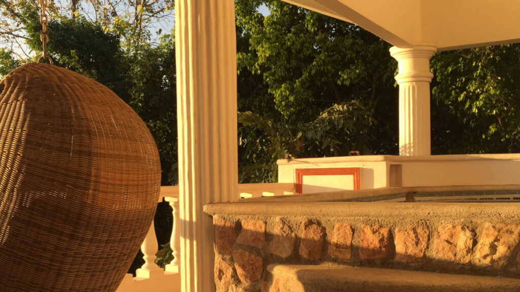 The porch area shows the classical architectural influence of columns and stone used throughout the villa.