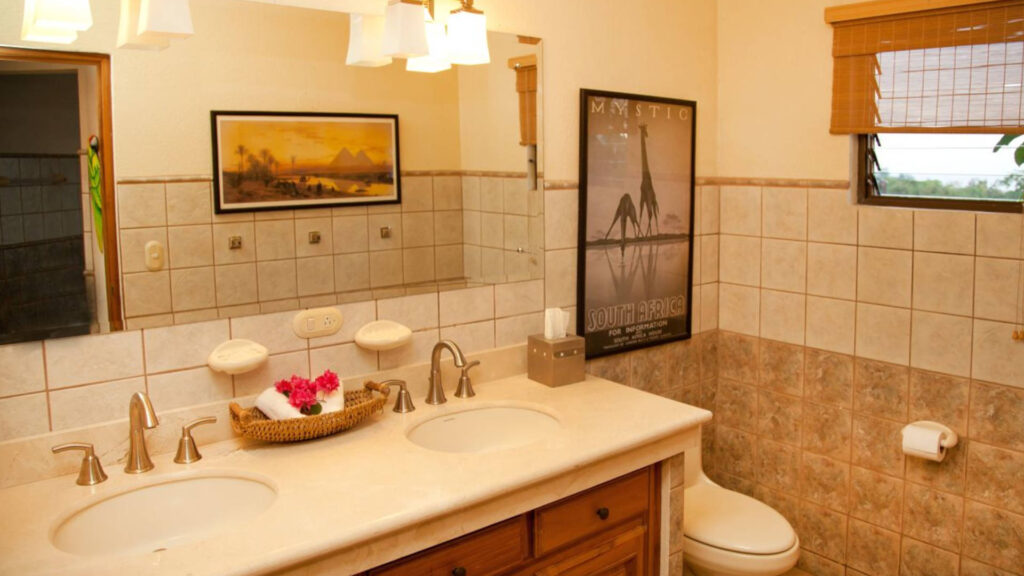 An extra large bathroom with beautiful tiles, marble counter tops, and his and hers sinks.