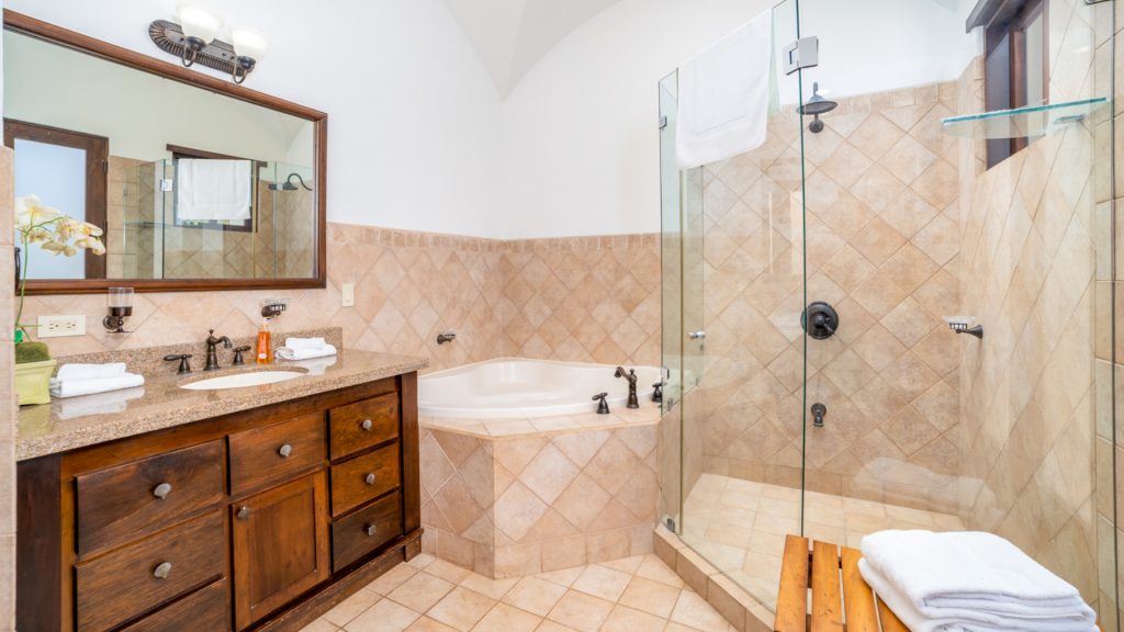 A very cleanly bathroom featuring a  glass wall shower.