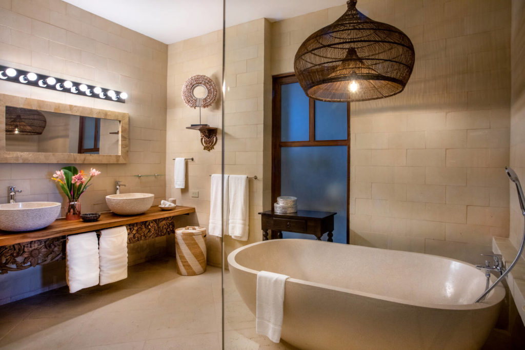 Natural stone his and hers sinks and a beautiful stone soaking tub feature in this luxury ensuite bathroom.