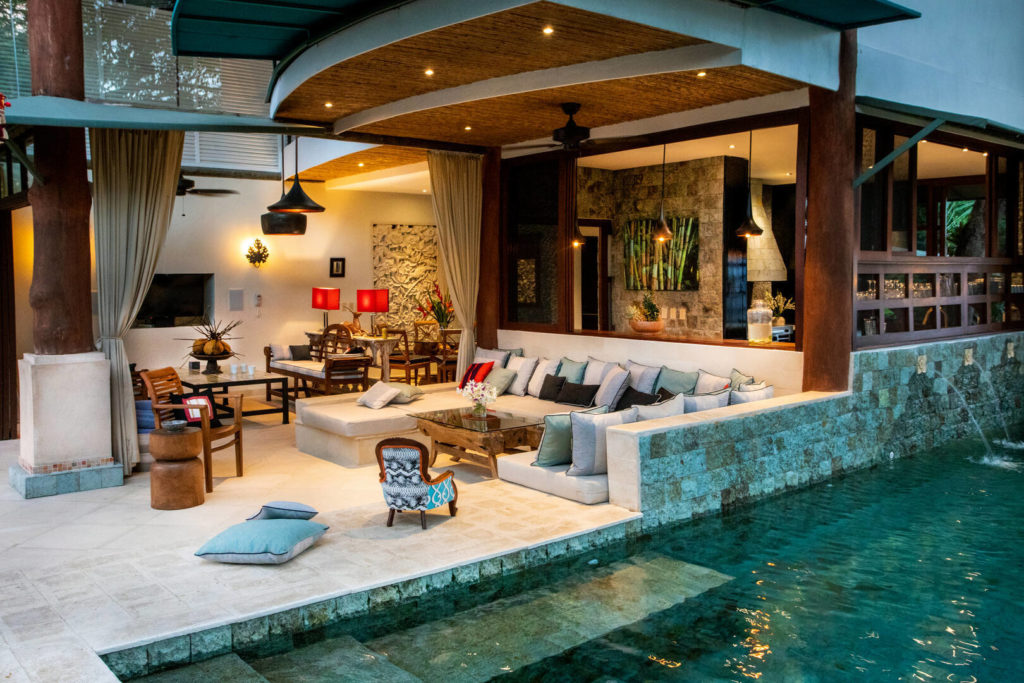 The outdoor living area is steps from the pool, perfect for a refreshing evening dip.