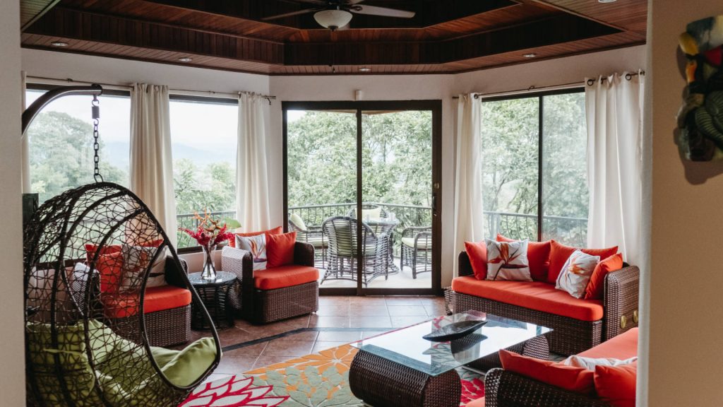 The gorgeous living room has some fun tropical details and a unique hanging papasan chair.