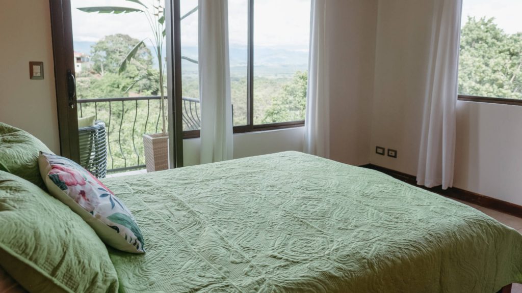 The mountain and ocean view from this bedroom can be enjoyed via large windows and the balcony.