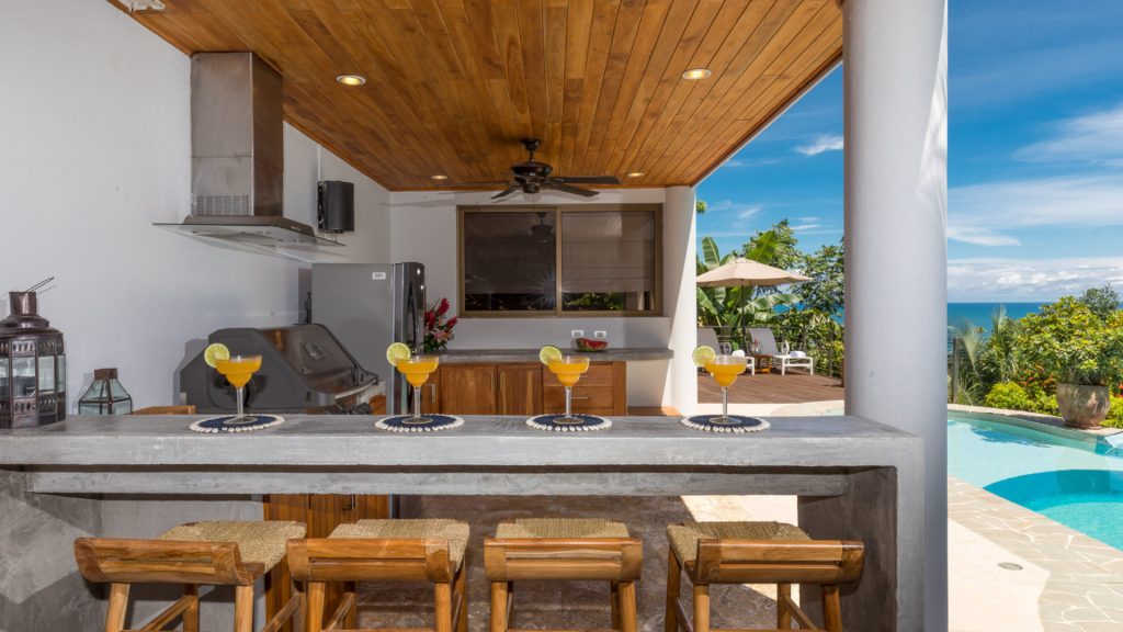 The outdoor kitchen with awesome bar seating and grill is perfect for a family pool day.