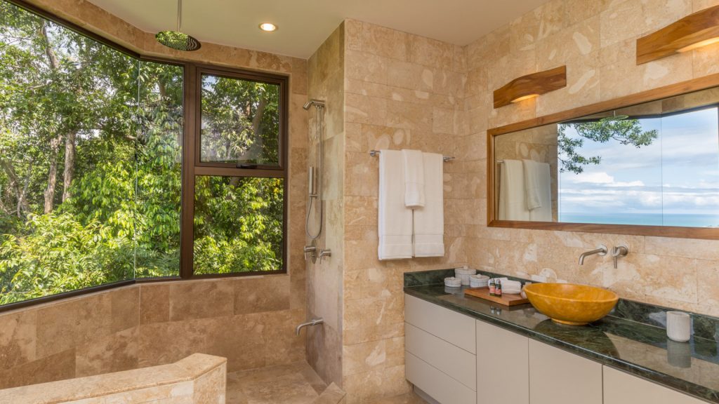 Large jungle-view shower and marble counters in one of the luxurious bathrooms.