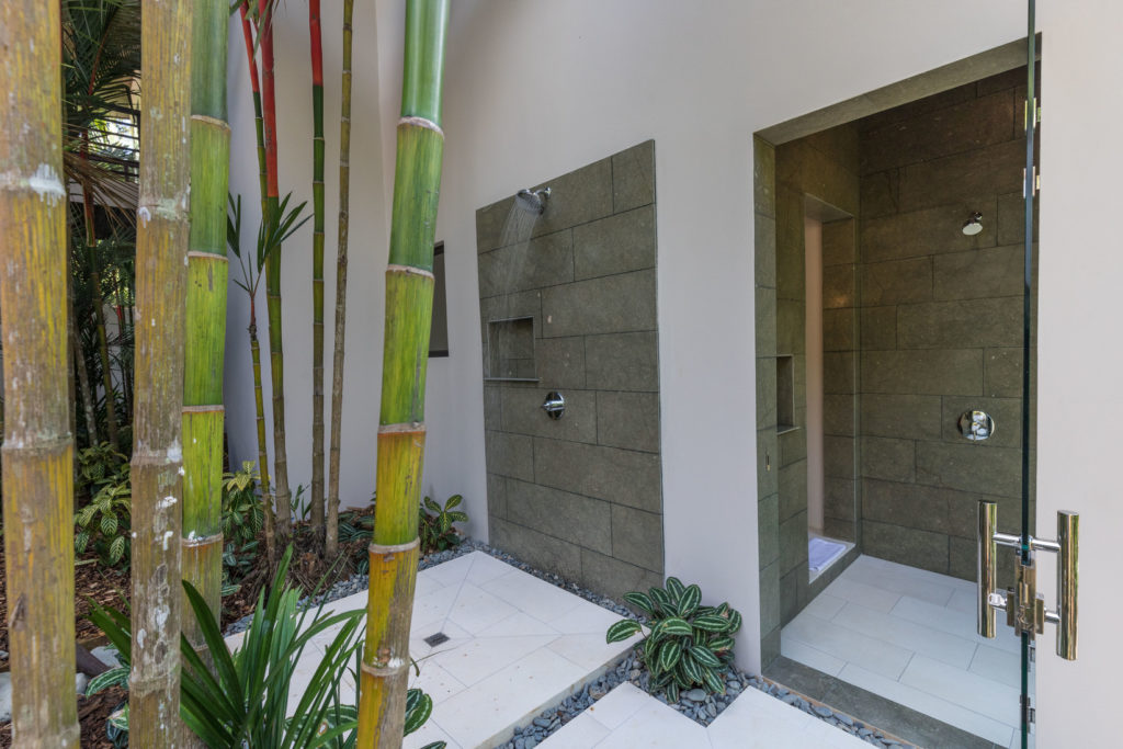 Two of the ensuite bathrooms include both indoor and outdoor showers with a view of the tropical garden.