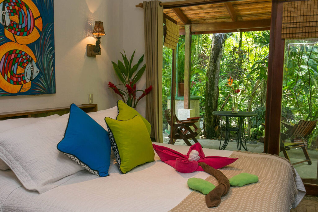 This colorful bedroom seems like it is deep in the jungle although it is steps from the beach.