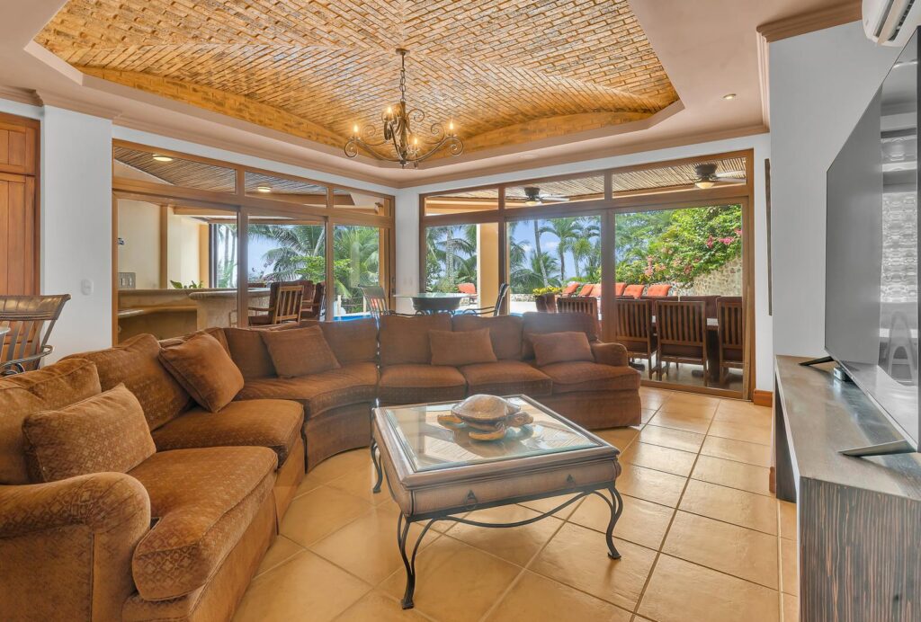 A spacious family room with comfortable seating opens directly to the outdoor terraces, creating an inviting space to relax after a day at the beach.