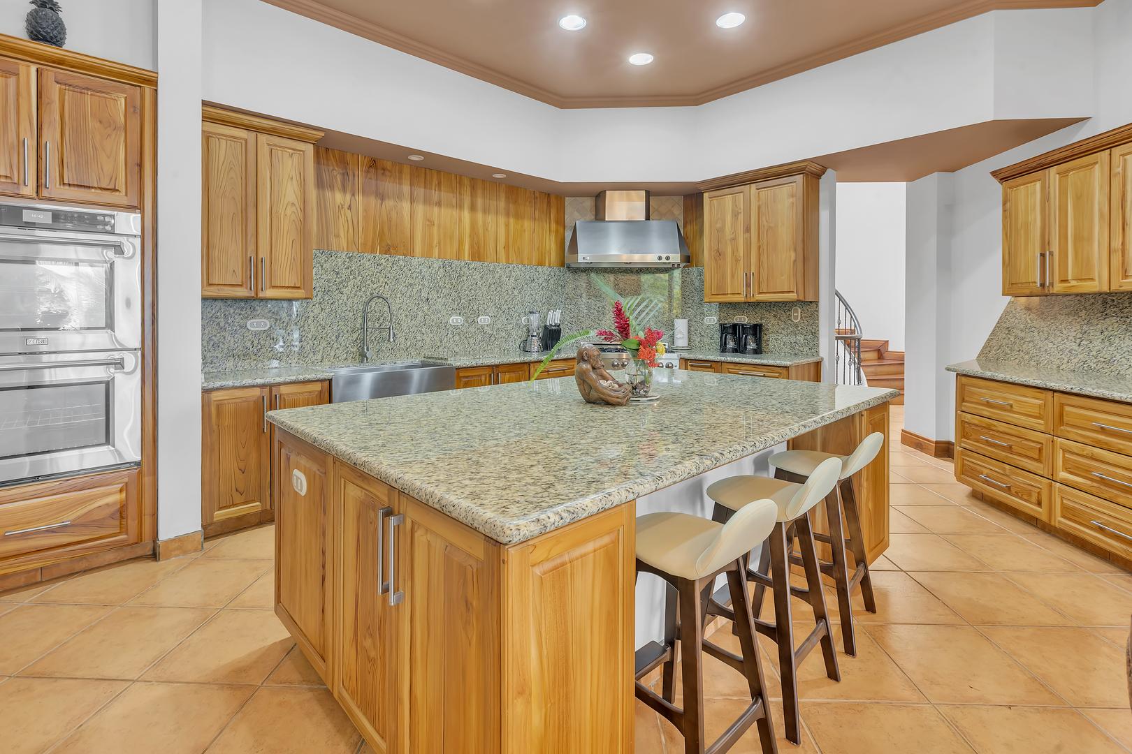 Gourmet kitchen with large island at a luxury beachfront vacation villa in Playa Tambor, Costa Rica.