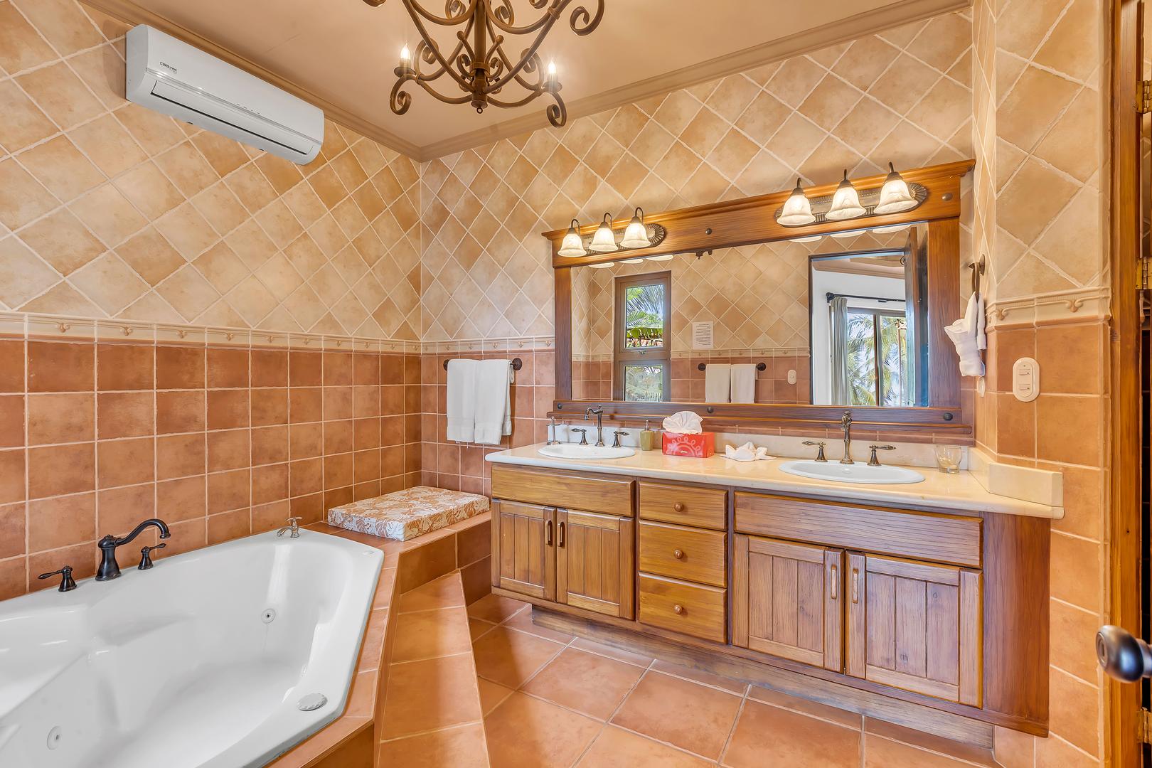 Primary bathroom with double vanity and soaking tub at a luxury beachfront vacation villa in Playa Tambor, Costa Rica.
