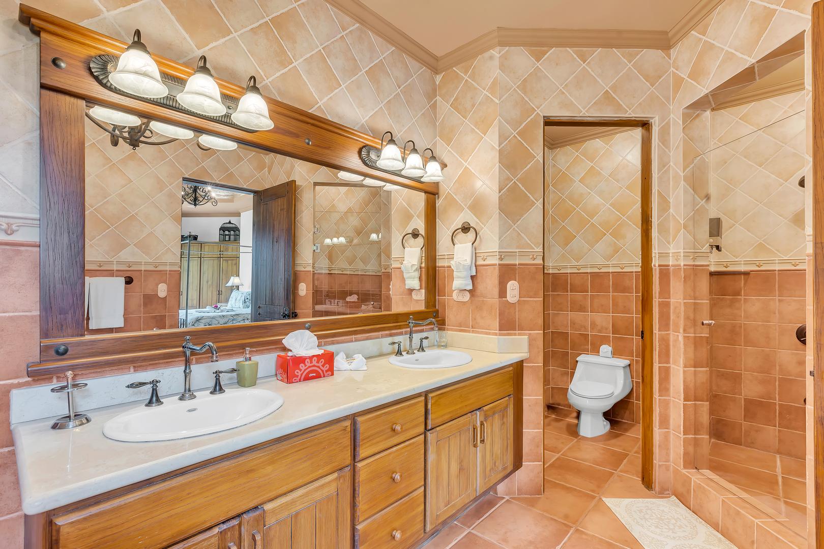 Primary bathroom with double vanity and walk-in shower at a luxury beachfront vacation villa in Playa Tambor, Costa Rica.