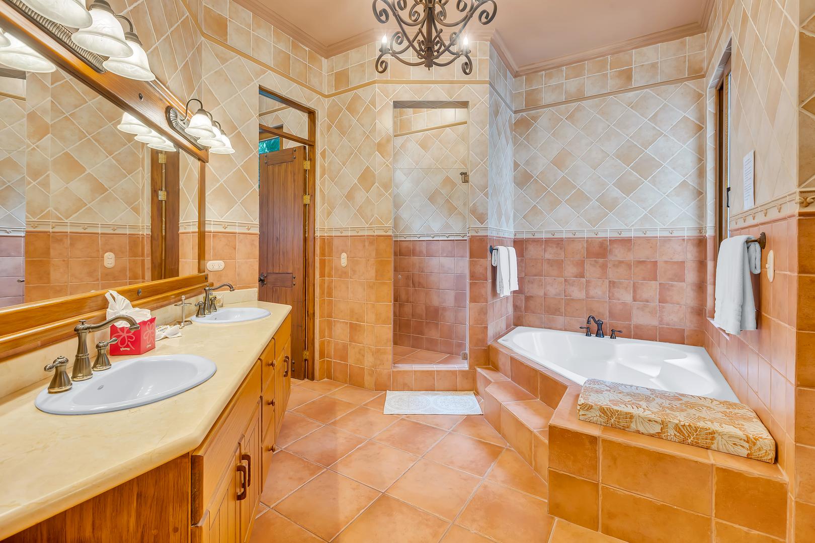 Luxury ensuite bathroom with soaking tub, walk-in shower, and double vanity in a beachfront vacation villa in Playa Tambor, Costa Rica.