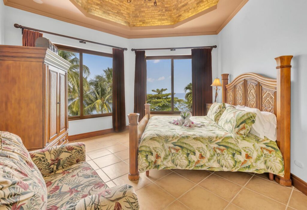 A spacious king bedroom offers panoramic Pacific Ocean views, handcrafted furnishings, and a peaceful setting for restful nights.