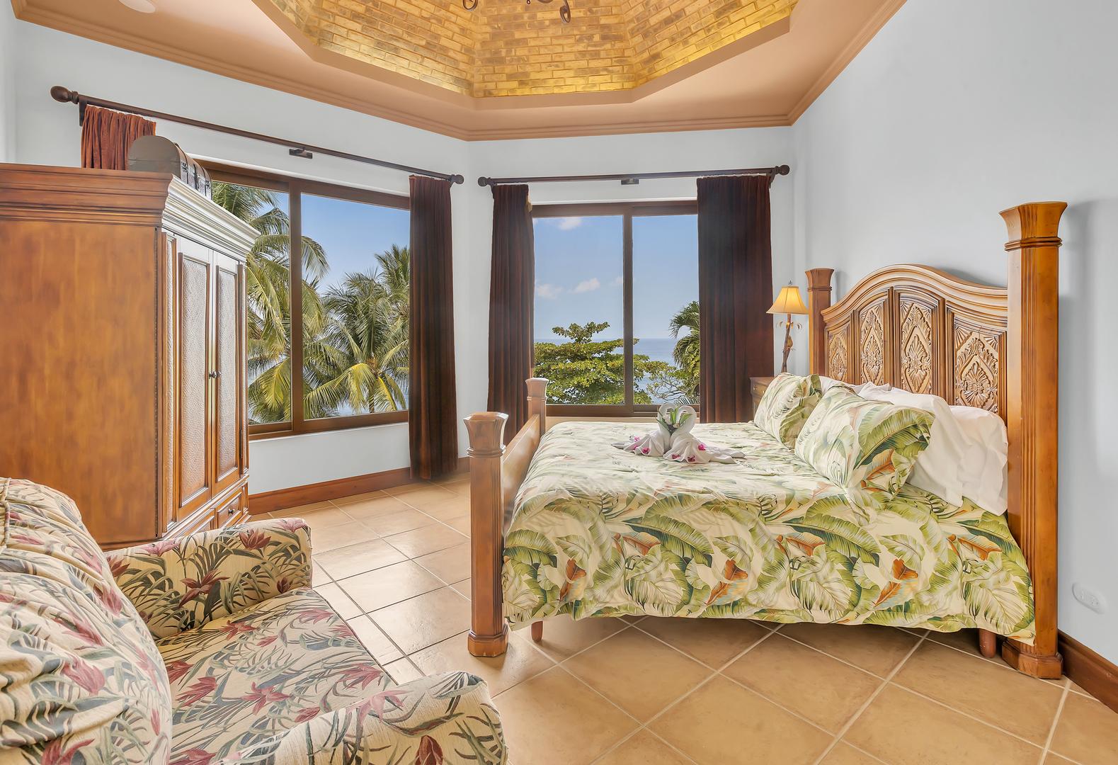 King bedroom with ocean-view windows at a luxury beachfront vacation villa in Playa Tambor, Costa Rica.