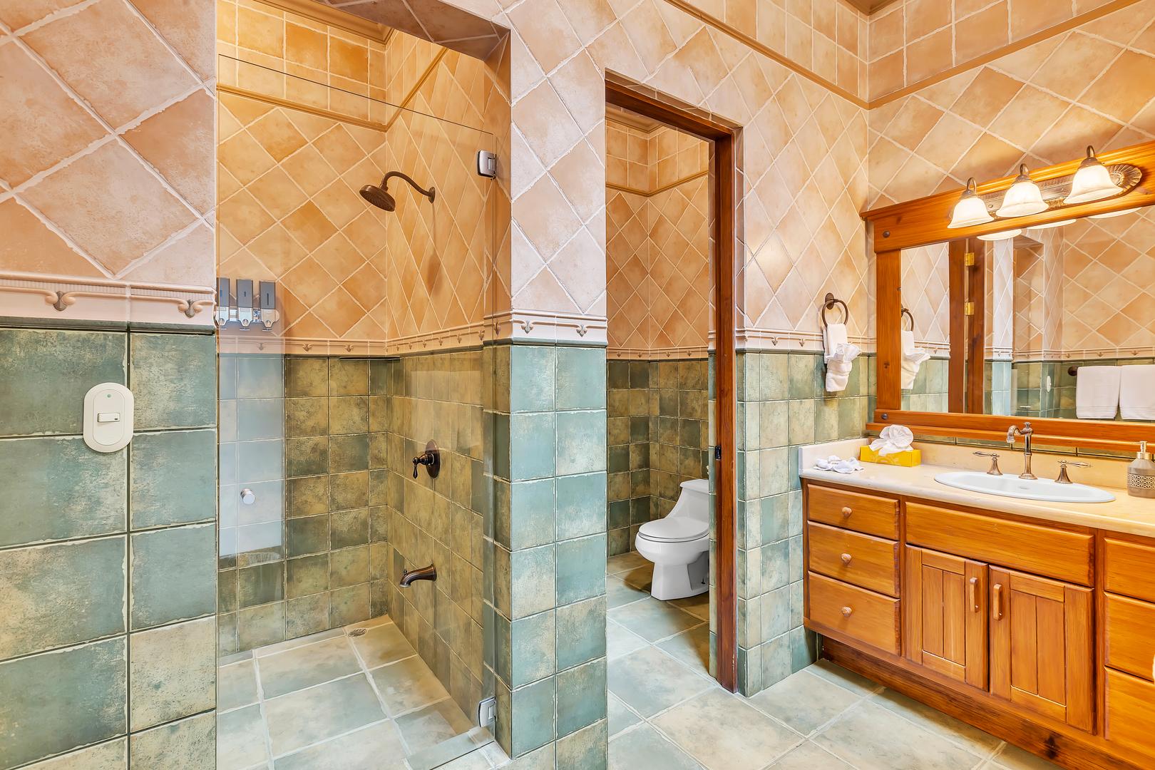 Ensuite bathroom with walk-in shower and wood vanity at a luxury beachfront vacation villa in Playa Tambor, Costa Rica.