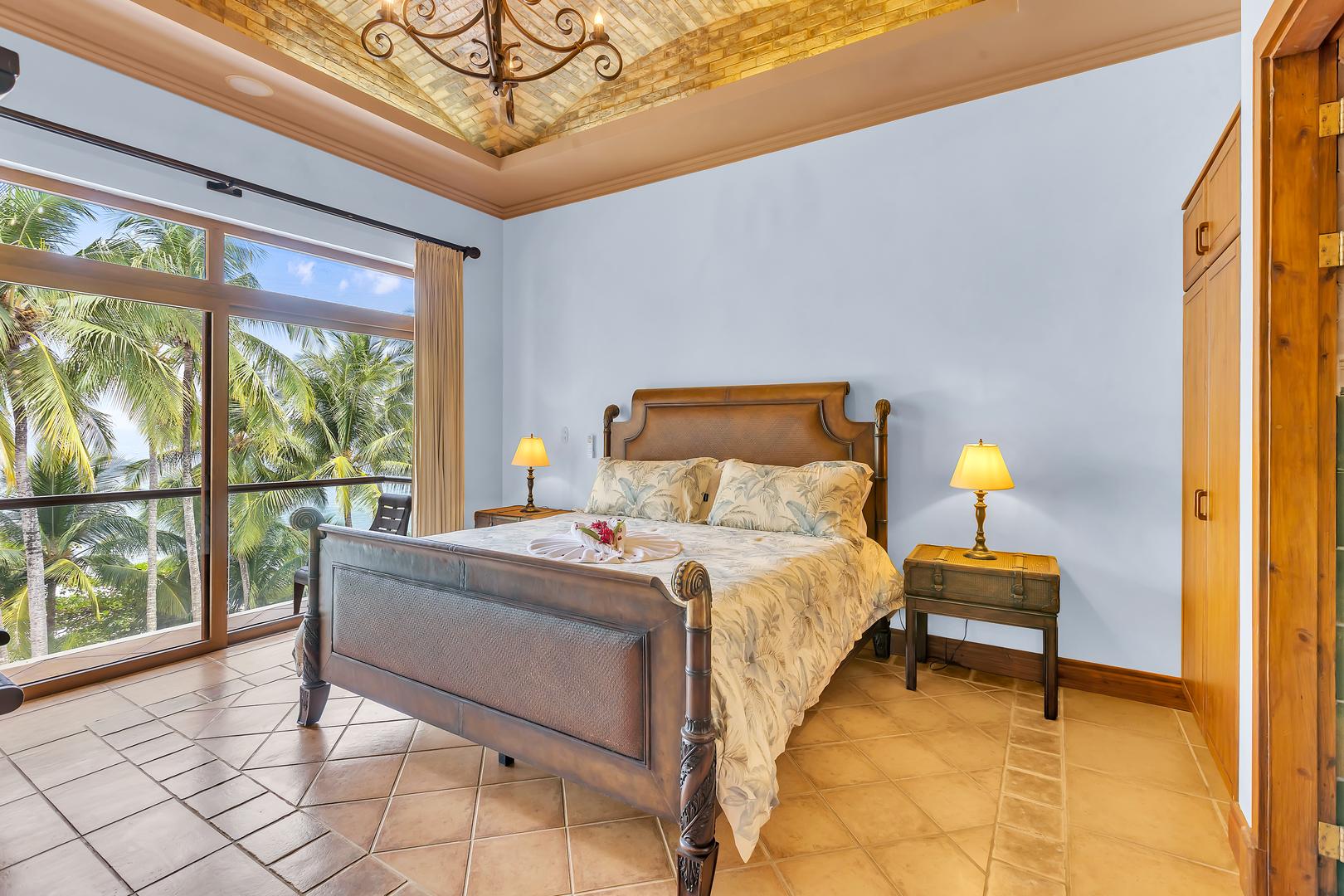 King bedroom with ocean-view balcony at a luxury beachfront vacation villa in Playa Tambor, Costa Rica.