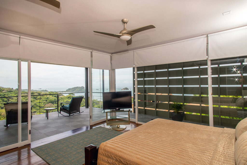 Another stunning bedroom with a balcony and another incredible ocean view.