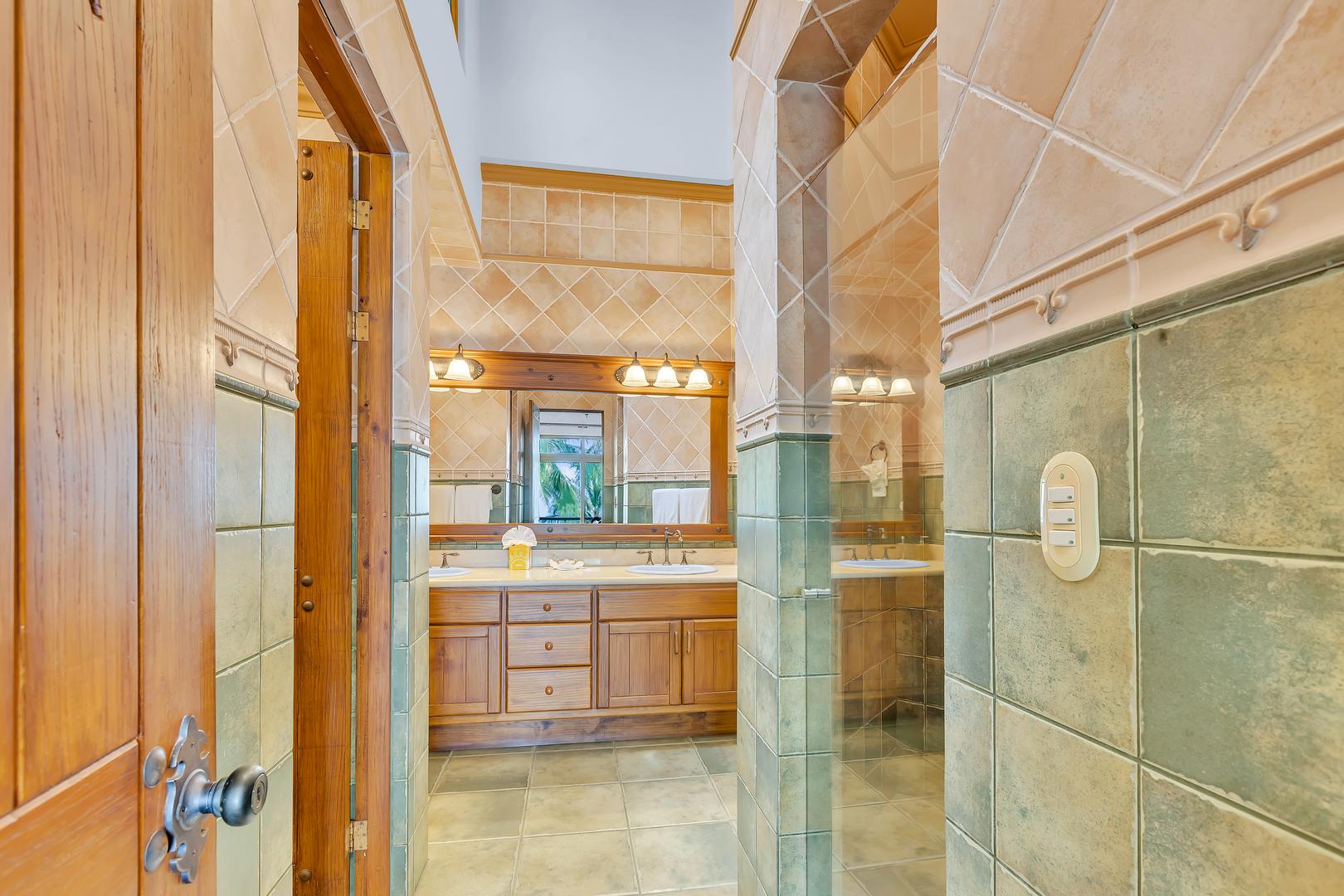 Entrance to an ensuite bathroom with walk-in shower at a luxury beachfront vacation villa in Playa Tambor, Costa Rica.