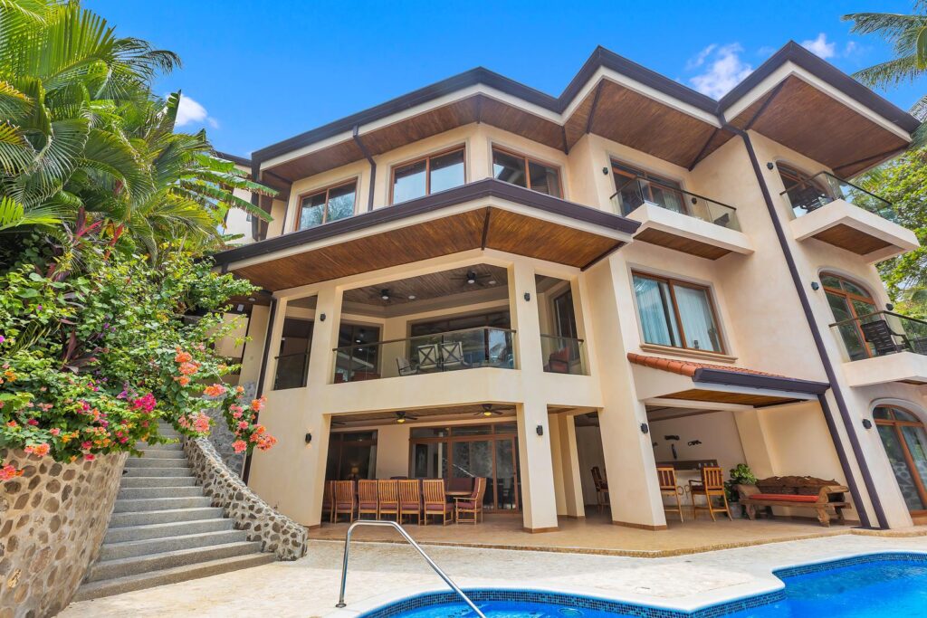 The villa's tropical architecture, spacious terraces, and private pool create an inviting beachfront retreat overlooking the Pacific Ocean.
