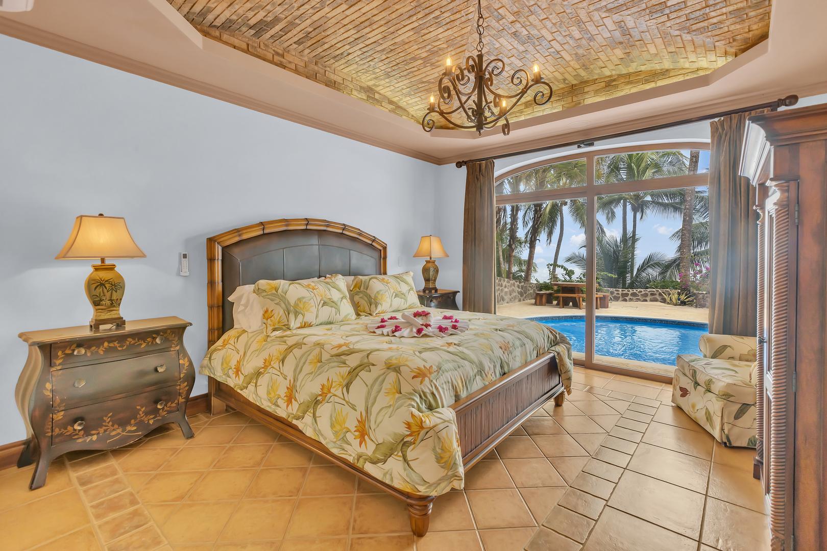 King bedroom with direct pool terrace access at a luxury beachfront vacation villa in Playa Tambor, Costa Rica.