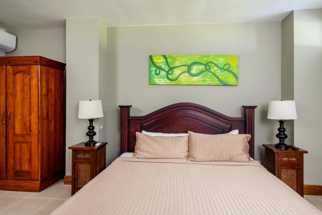 Beautiful wooden furniture and exotic art adorn this comfortable bedroom.