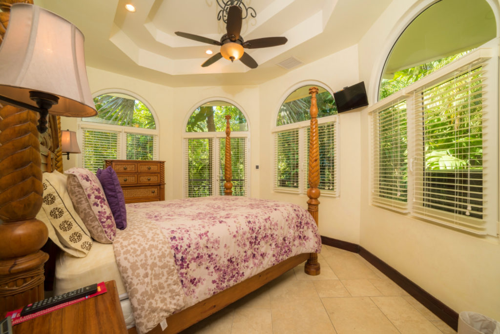 Embrace luxury living in this bedroom. Enjoy a serene view of lush, vibrant gardens, offering a perfect start to your day
