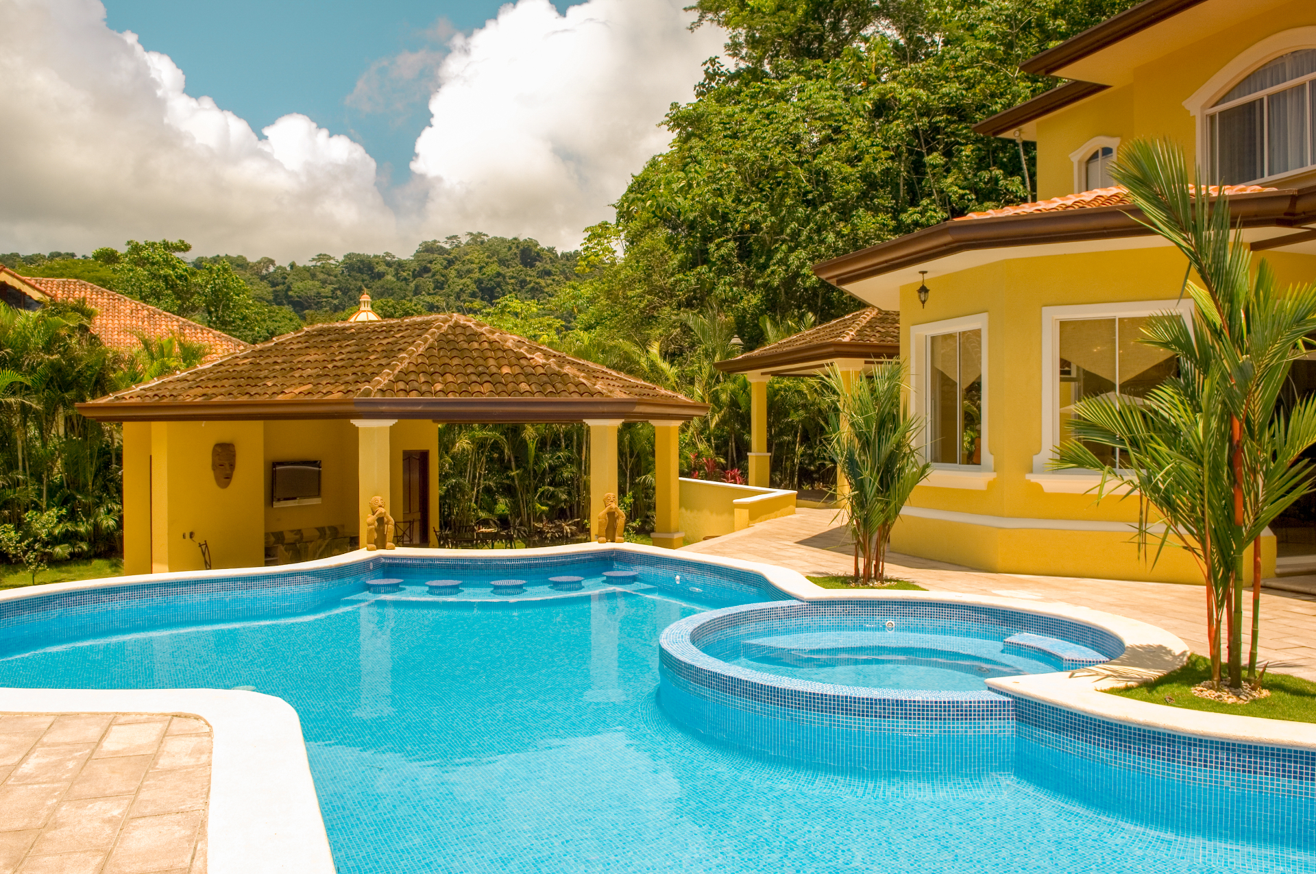 Private pool and jacuzzi with covered pavilion and tropical landscaping at a Los Sueños luxury villa.