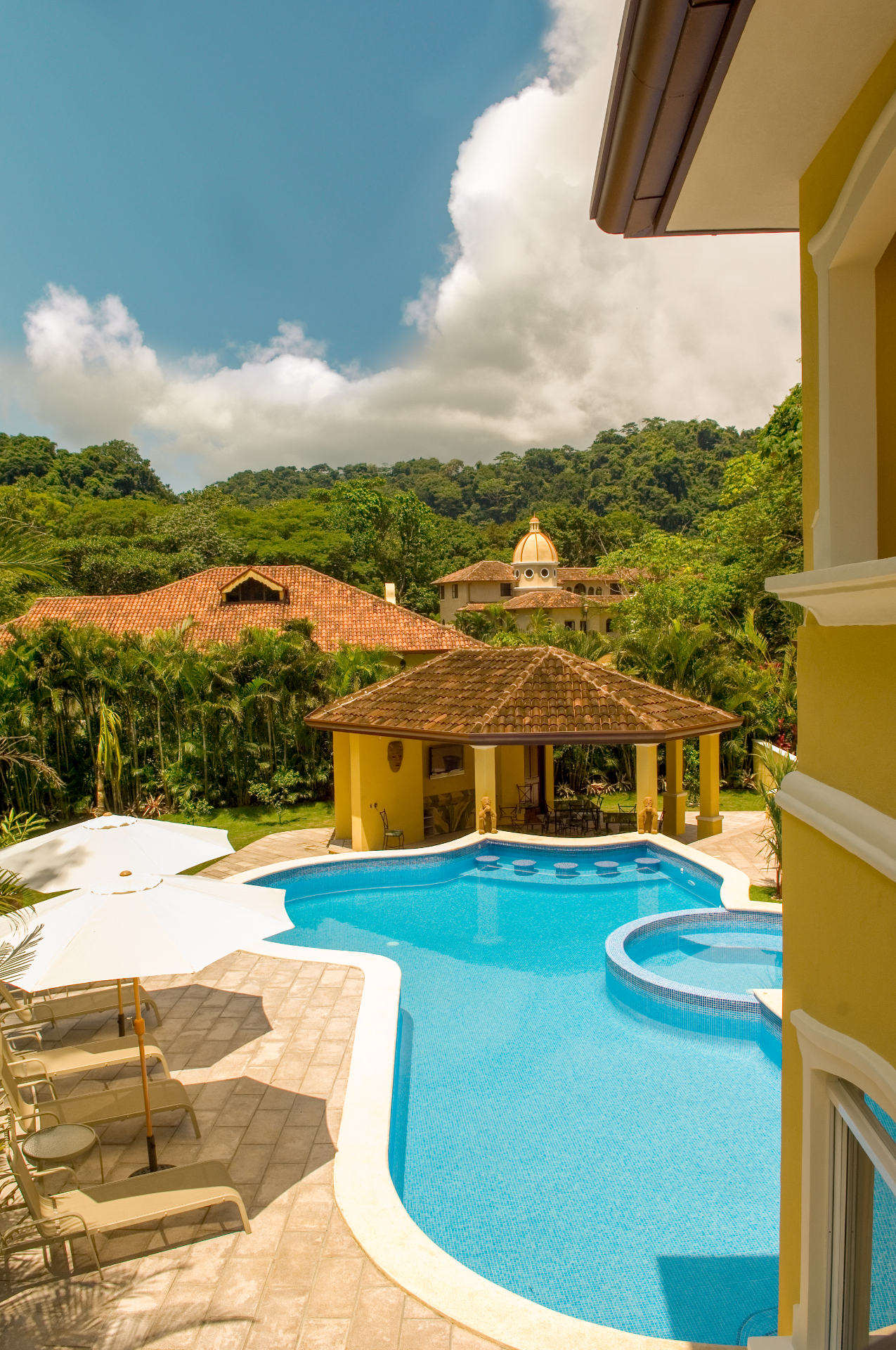 Elevated view of private pool, jacuzzi, and covered poolside pavilion at a Los Sueños resort villa in Costa Rica.