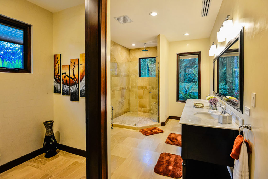 A spacious, elegant bathroom featuring a generously sized shower and ample, well-placed lighting