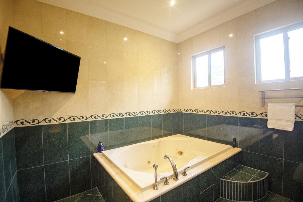 Indulge in our sophisticated bathroom with a TV-equipped tub.